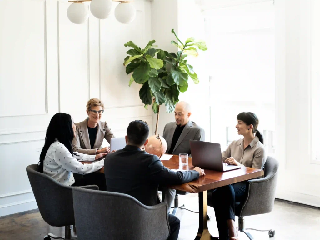 Equipo de profesionales de una agencia de Fansly colaborando en una reunión para crear estrategias de crecimiento
